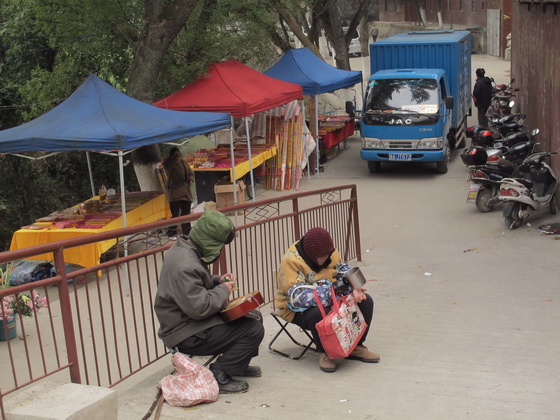 芸を演じて喜捨を乞う盲人