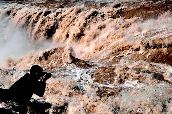 撮影愛好者は黄河壺口瀑布の「桃花汛」の美景を取っている